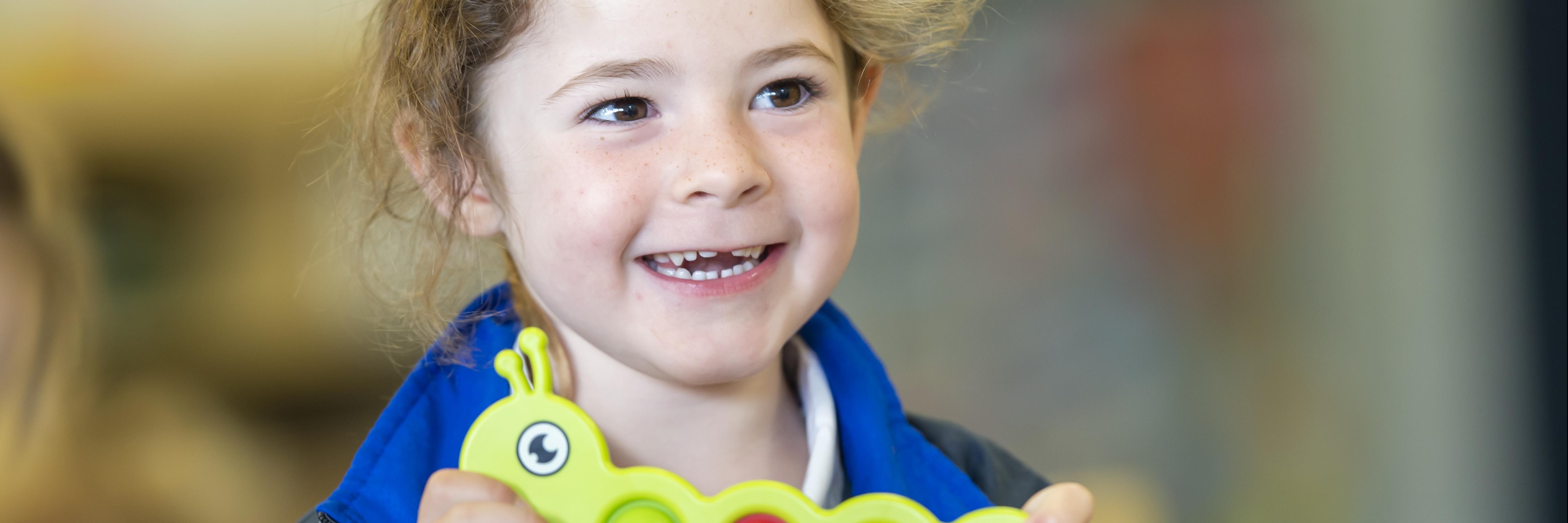 Child smiling holding toy